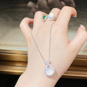 Detailed view of silver bow jewelry set with chalcedony pendants and gemstone rings