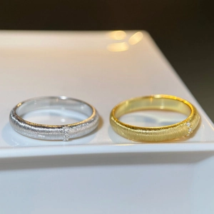 Macro shot of 925 silver and 18K gold plated rings with brushed finish and three diamonds