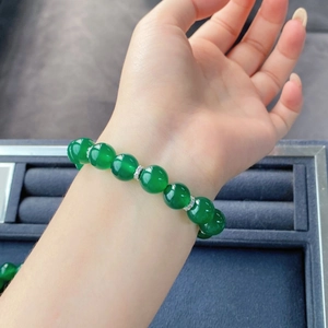 Détail macro de perles en agate vert émeraude avec accents en cristal sur poignet féminin