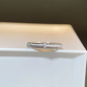 Macro shot of brushed 925 silver ring featuring three small inlaid zircons and textures
