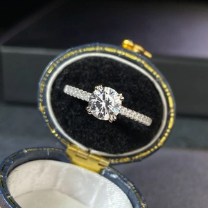 Macro detail of 1 carat moissanite ring with four-prong setting in a blue velvet box