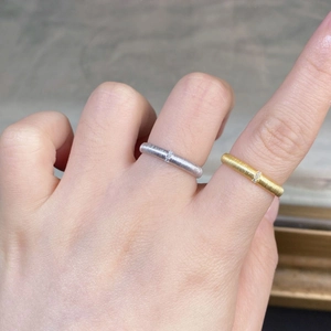 Detail of minimalist 925 sterling silver brushed rings with small inset diamonds