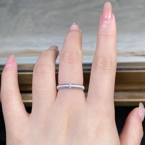 Detailed close-up of a silver brushed texture ring with three tiny crystals on a female hand