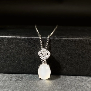 Dettaglio di una collana in argento con pendente ovale in calcedonio bianco e cristalli pavé