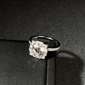 Close-up of a 925 sterling silver moissanite ring with halo setting on a black gift box