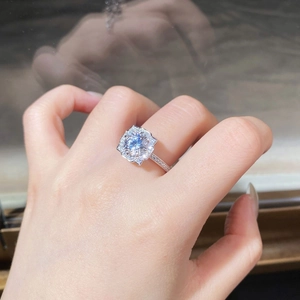 Macro detail of silver ring featuring round center stone with pave setting on the hand