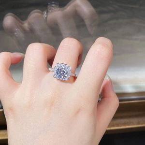 Detailed macro view of a 925 silver moissanite ring with halo setting on a finger