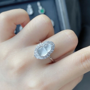 Gros plan d'une bague en argent avec pierre de gourde translucide et pavé de diamants