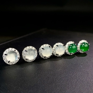Detail of silver stud earrings with chalcedony gemstones and crystal halo on dark leather