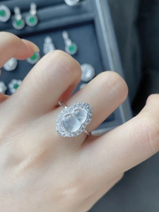 Gros plan d'une bague en forme de hulu avec zircons scintillants portée sur le doigt