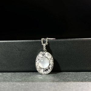 Gros plan d'un pendentif ovale en pierre de lune avec pavé de diamants sur chaîne argent