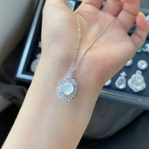Gros plan d'un collier en argent avec calcédoine blanche et bordure en zircon