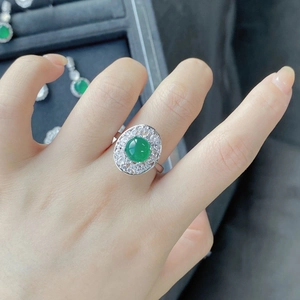 Macro shot of silver ring with green chalcedony stone and pavé zircons on finger