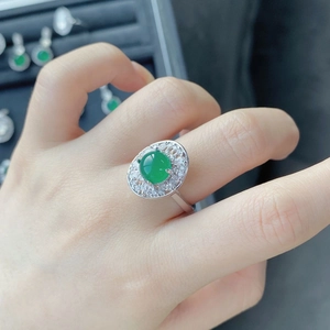 Macro detail of royal green chalcedony ring with crystal halo on woman's finger