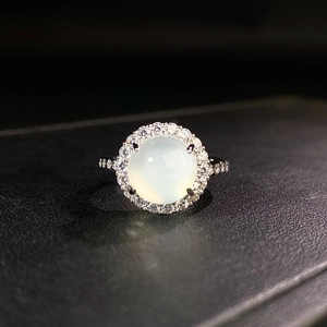 Macro shot of halo ring featuring light green chalcedony stone and sparkling zircon border