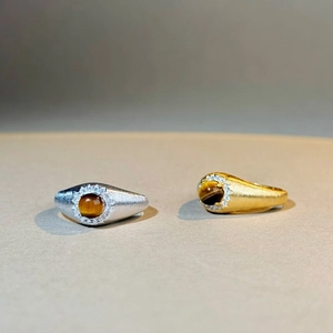 Détail de bagues en argent et or brossé avec pierres œil de tigre et éclats de zircon