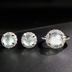 Macro detail of silver halo ring and earrings set with translucent white chalcedony