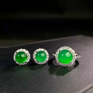 Detail view of emerald green chalcedony ring and earrings with halo diamond setting