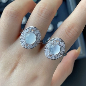 Close-up of elegant silver rings with white chalcedony stones and halo zircon settings