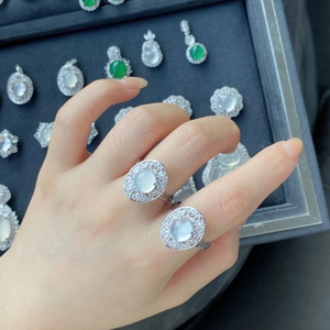Detail of two silver rings with high-ice chalcedony stones and halo diamond settings