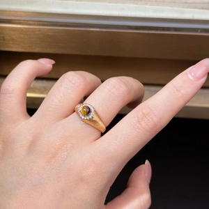 Détail d'une bague en argent brossé avec pierre œil de tigre ronde sur une main de femme