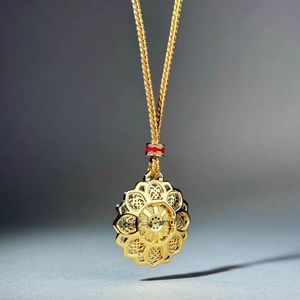 Golden lotus mandala pendant necklace with red enamel bead on braided chain