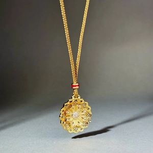 Detail of gold lotus pendant with red decorative ring and intricate layered petals
