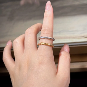 Close-up of Mobius silver and gold rings with twisted design and sparkling stones