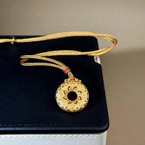 Goldener Kompass-Anhänger mit Wolkenmuster an einer verstellbaren geflochtenen Kette