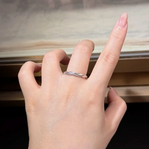 Close-up of S925 sterling silver Mobius ring featuring hand-brushed finish and pave diamonds