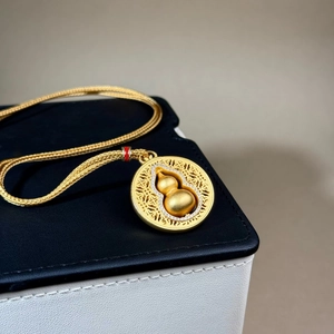 Collier avec pendentif calebasse dorée tournante et chaîne tissée élégante