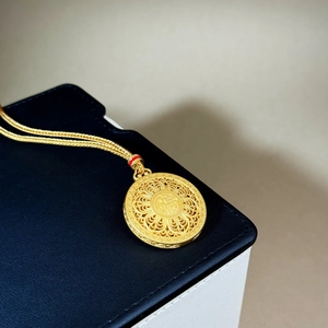 Golden sand gold Fu character pendant necklace with intricate filigree openwork design