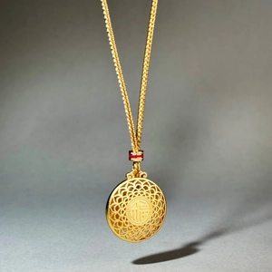Collana con ciondolo Fu dorato con motivo traforato e catena intrecciata regolabile