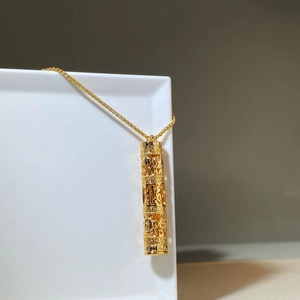Collier cylindrique doré avec gravure filigrane traditionnelle et chaîne fine