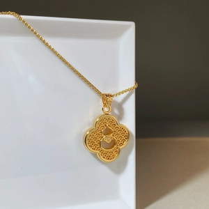Gold-plated necklace with hollow petal pendant and gourd element on a white display board