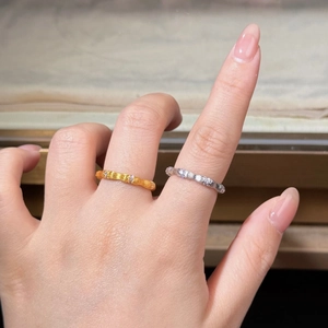 Detail of silver bamboo style rings with textured finish and diamonds on model fingers
