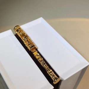 Vue macro détaillée d'un pendentif filigrane plaqué or orné de reliefs de dragon en coffret