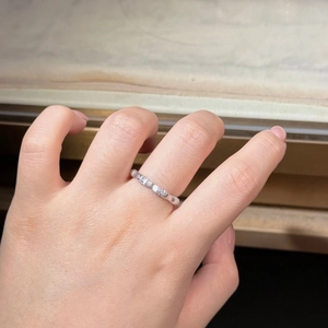 Close-up of a wavy S925 sterling silver bamboo ring with diamonds on a finger