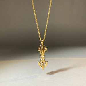 18K gold plated vajra pestle necklace with diamond accents on minimalist background