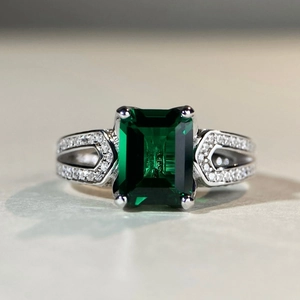 Macro di anello con pietra verde taglio smeraldo e gambo geometrico con diamanti