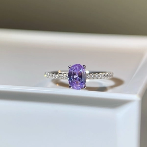Macro shot of a 1ct oval purple gemstone ring with sparkling pavé side stones