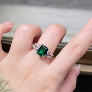 Elegante anello in argento 925 con gemma verde taglio smeraldo e fascia incrociata di diamanti
