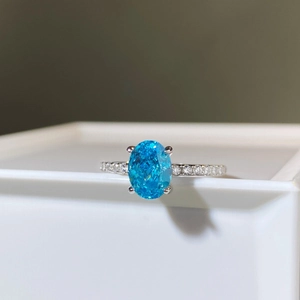 Détail d'une bague en argent S925 avec pierre bleue ovale et pavage de diamants