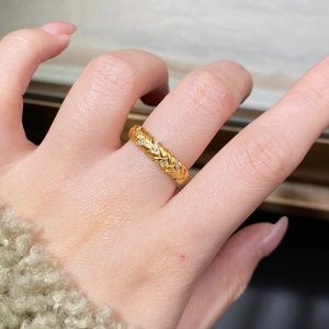 Macro detail of 18K gold wheat grain texture ring with embedded diamonds worn on finger