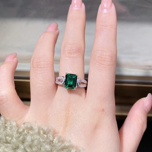 Vista macro di un anello con gemma taglio smeraldo e pavé su fascia in argento