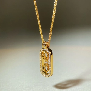 Makroaufnahme von 18K vergoldetem Vajra-Anhänger mit Zirkonias an einer Kordelkette