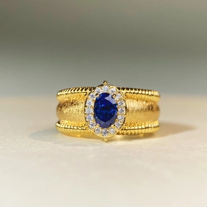 Vintage 18K gold plated ring with blue sapphire center stone and brushed texture