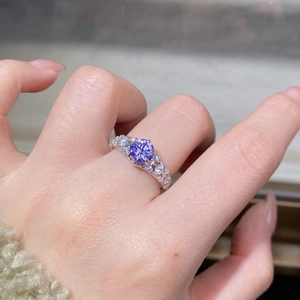 Gros plan d'une bague vintage en argent avec pierre violette 1ct et diamants pavés fins