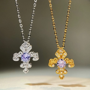 Détail de pendentifs en croix avec pierres lavande et gravures ajourées