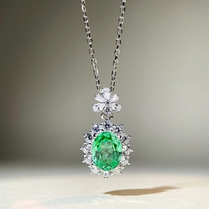 Détail macro du collier luxe en argent S925 avec pierre verte ovale et halo de zircon